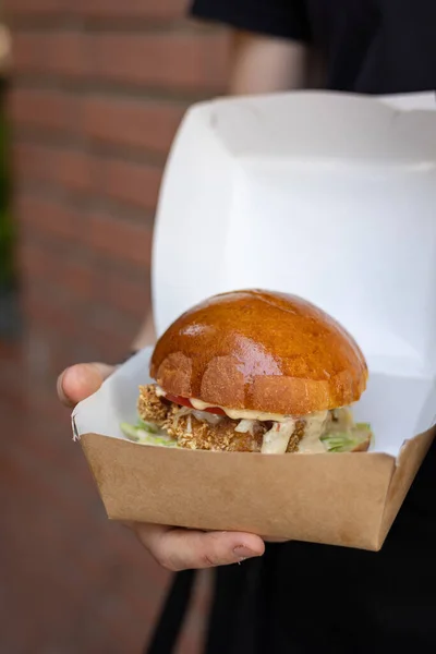 burger with chicken, tomato and onion on wooden background