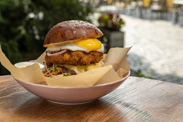 burger with chicken, tomato and onion on wooden background