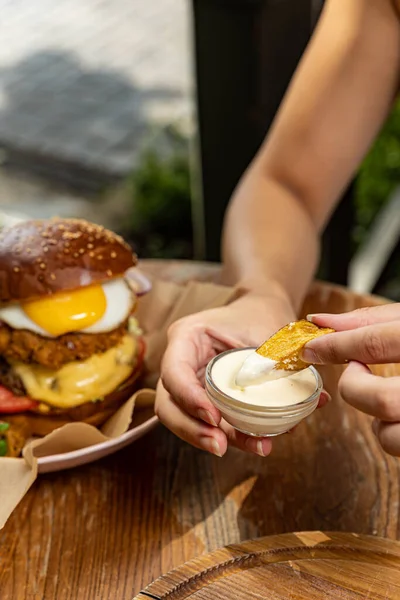 burger with chicken, tomato and onion on wooden background