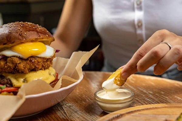 burger with chicken, tomato and onion on wooden background