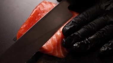 Şef Dilimleme somon kapatın. Kesme tahtası üzerinde çiğ balık.  