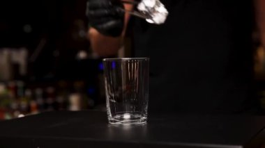 Barmen barda bir kokteyl hazırlıyor.