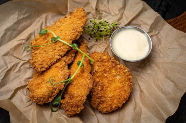 Siyah arka planda bir tavada haşlanmış deniz ürünleri.