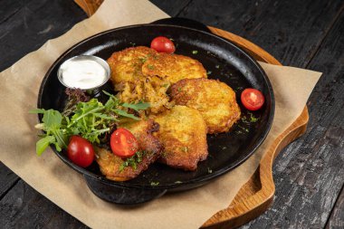 Siyah arka planda bir tavada haşlanmış deniz ürünleri.