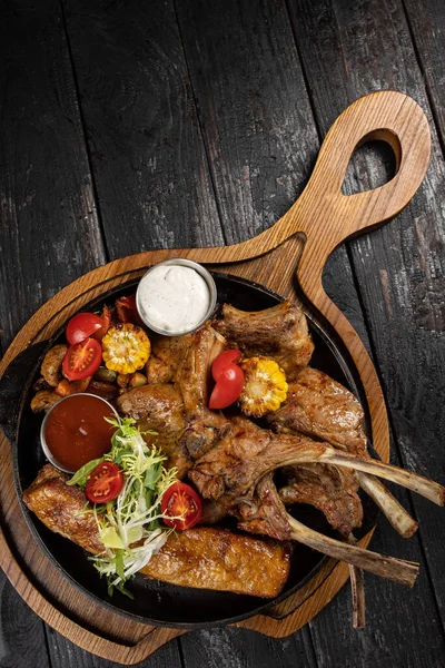 Siyah arka planda ızgara et ve sebze.