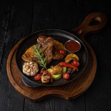 Siyah arka planda ızgara et ve sebze.