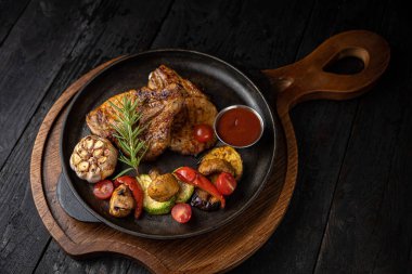 Siyah arka planda ızgara et ve sebze.