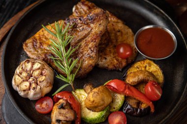 Siyah arka planda ızgara et ve sebze.