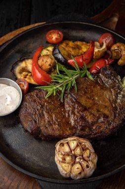 Siyah arka planda ızgara et ve sebze.