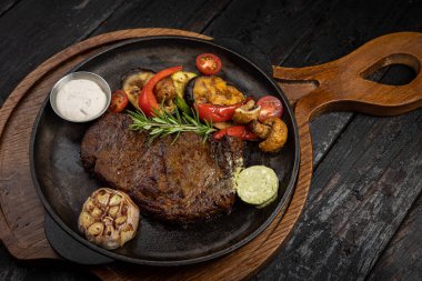 Siyah arka planda ızgara et ve sebze.