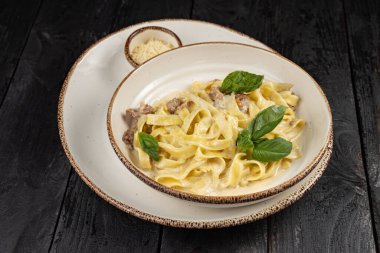 Peynirli makarna, yeşillik, restoranda sos.