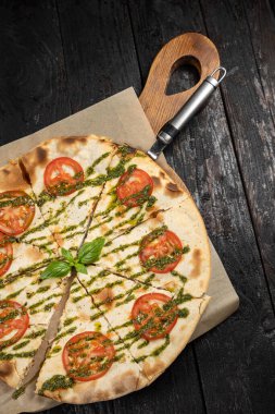 Peynirli lezzetli pizza, yeşillik, restoranda sos.