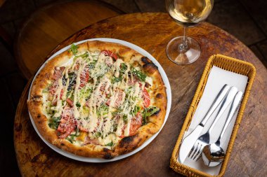 Peynirli lezzetli pizza, yeşillik, restoranda sos.