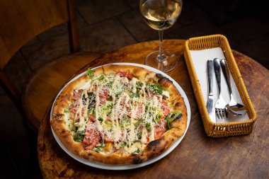 Peynirli lezzetli pizza, yeşillik, restoranda sos.