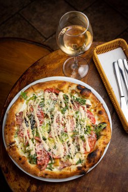 Peynirli lezzetli pizza, yeşillik, restoranda sos.