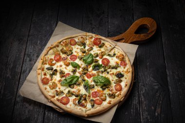 Peynirli lezzetli pizza, yeşillik, restoranda sos.
