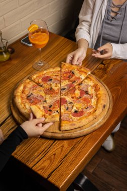 Peynirli lezzetli pizza, yeşillik, restoranda sos.