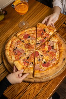 Peynirli lezzetli pizza, yeşillik, restoranda sos.