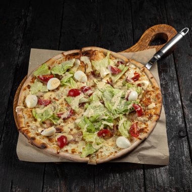 Peynirli lezzetli pizza, yeşillik, restoranda sos.