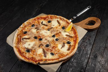 Peynirli lezzetli pizza, yeşillik, restoranda sos.