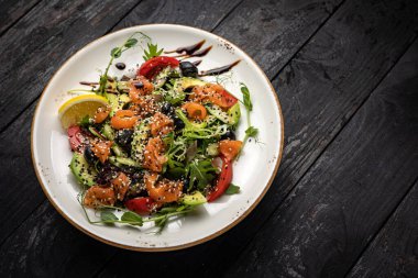 Avokado ve roka ile siyah somon salatası.