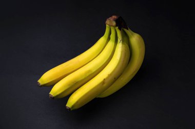 Siyah arka planda bir grup olgun muz.