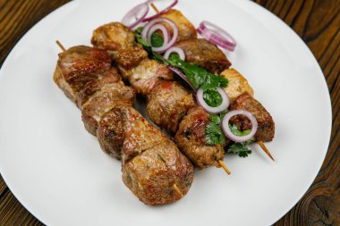Fırında et, ahşap bir masada barbekü.