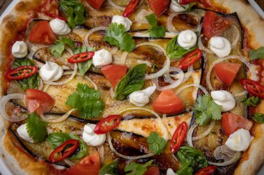 Restoranda patlıcanlı, peynirli, domatesli ve biberli pizza.