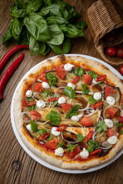Restoranda patlıcanlı, peynirli, domatesli ve biberli pizza.