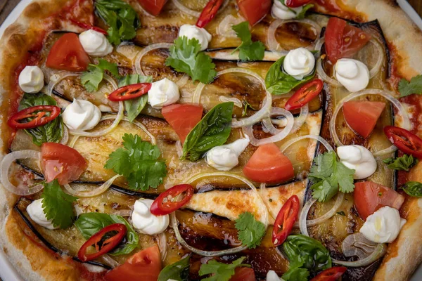 Restoranda patlıcanlı, peynirli, domatesli ve biberli pizza.