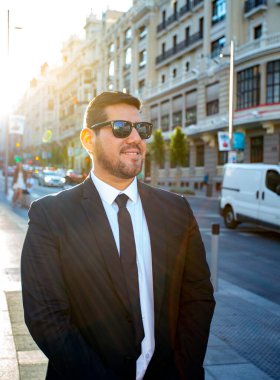 Takım elbiseli Latin adam taksi bekliyor.