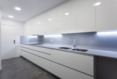 Büyük beyaz mutfak ve sade dolaplar.