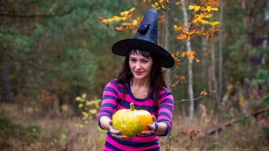 Cadılar Bayramı kostümlü mutlu kadın ve sarı balkabağı. Cadılar Bayramı konsepti
