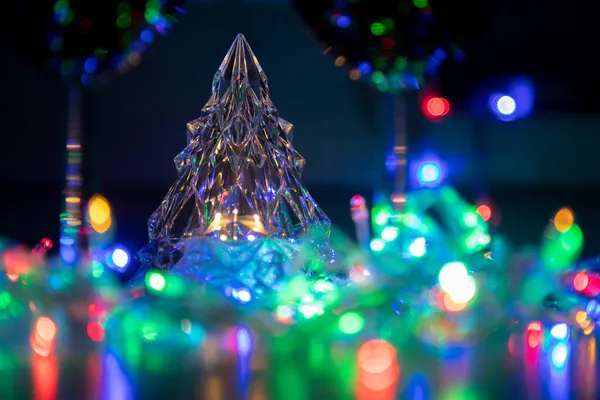 Cristal brilhante árvore de Natal cercada por guirlanda brilhante no escuro. conceito de ano novo e natal — Fotografia de Stock