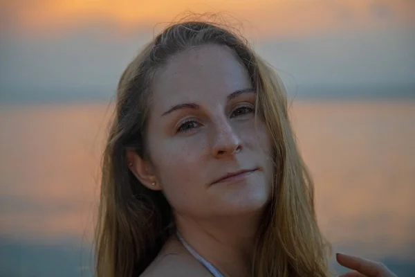 Portret van mooie Kaukasische vrouw in zee zonsondergang — Stockfoto