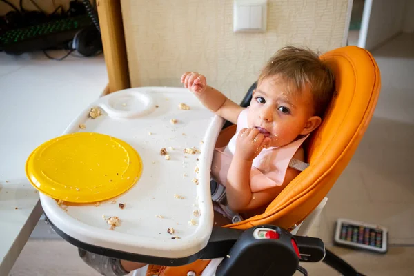 Lindo pequeño bebé comiendo en silla de bebé — Foto de Stock