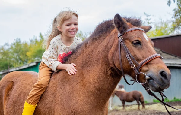 Foto Uma criança pequena montando um cavalo na frente de um celeiro –  Imagem de México grátis no Unsplash