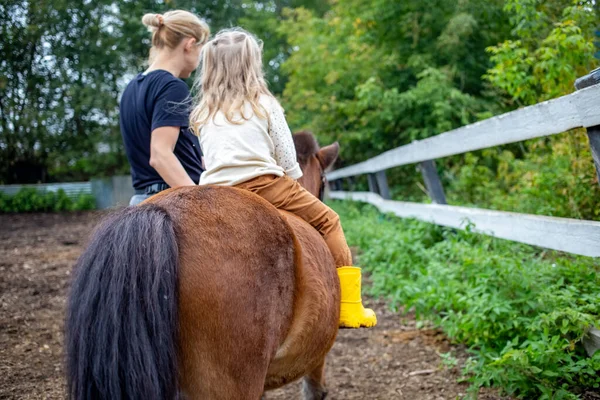 可爱的小女孩和教练一起骑着一匹小马。后视镜，后视镜 — 图库照片