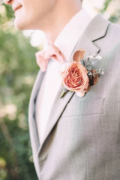 groom in a suit close-up, boutonniere on the lapel