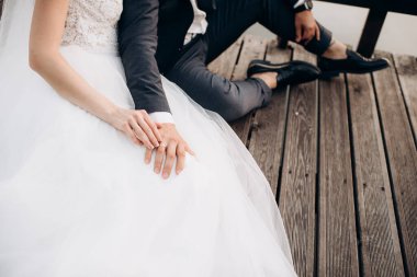 Birbirini seven yeni evli çiftler nazikçe elele tutuşur, yakın plan.