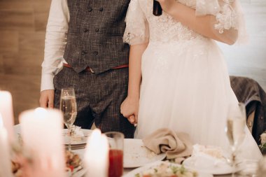 Birbirini seven yeni evliler nazikçe el ele tutuşuyorlar.