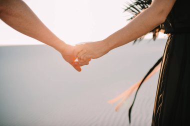 Birbirini seven yeni evliler nazikçe el ele tutuşuyorlar.