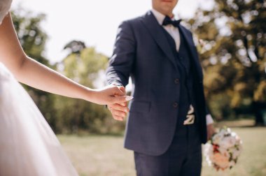 Birbirini seven yeni evliler nazikçe el ele tutuşuyorlar.