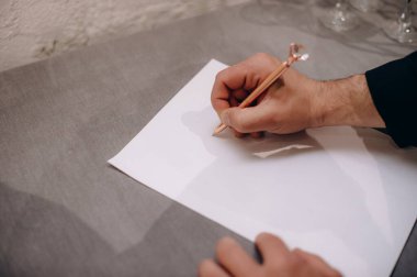 Adam boş bir kağıda kalemle yazıyor.