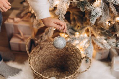 parıldayan gümüş Noel oyuncakları kadınların ellerinde, Noel ağacı süslemeleri