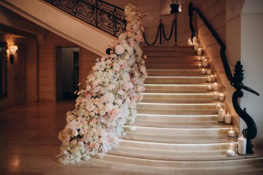 Merdivenler beyaz ve pembe çiçeklerle süslenmiş.