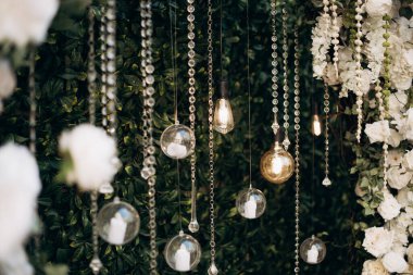 Yeşil arka planda şeffaf cam toplar ve mumlarla dekore edilmiş.