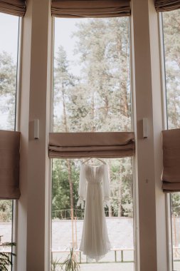 Gelinlik panoramik pencerede asılı.