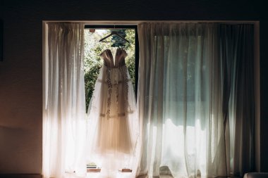 Gelinlik panoramik pencerede asılı.