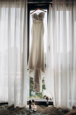 Gelinlik panoramik pencerede asılı.